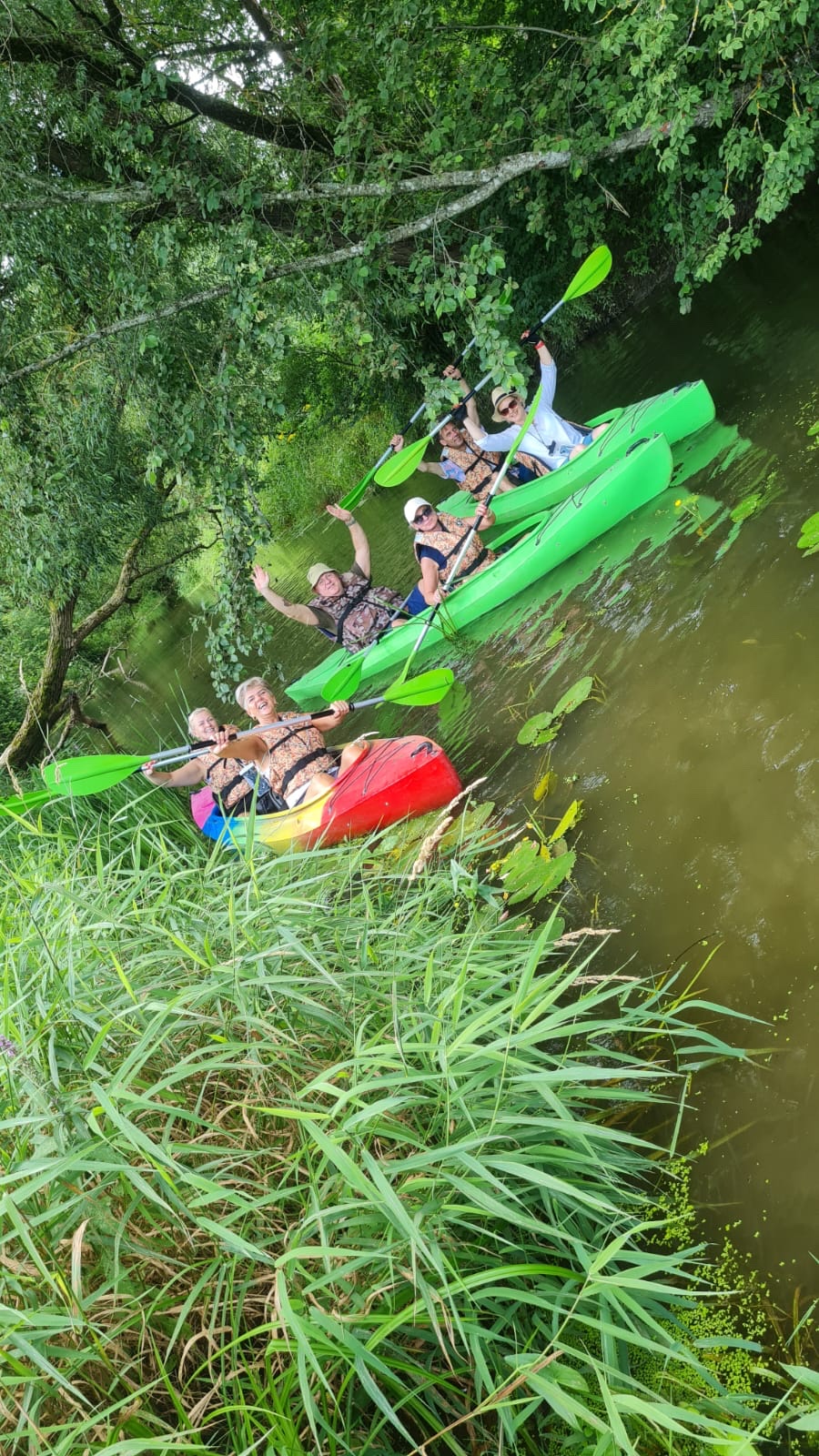 Grupė žmonių baidarėse mojuoja